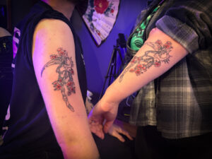 Couples matching arm scythe tattoo